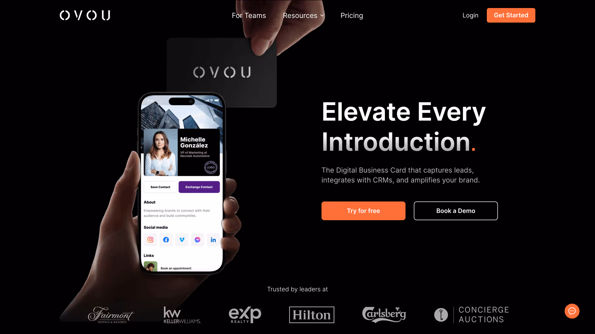 Hand holding a smartphone displaying a digital business card for Michelle Gonzalez with contact options and social media icons, and another hand holding a black OVOu card above it. Text to the right reads: Elevate Every Introduction. The Digital Business Card that captures leads, integrates with CRMs, and amplifies your brand, with buttons to try for free or book a demo. Logos of Fairmont Hotels & Resorts, Keller Williams, eXp Realty, Hilton, Carlsberg, and Concierge Auctions appear below.